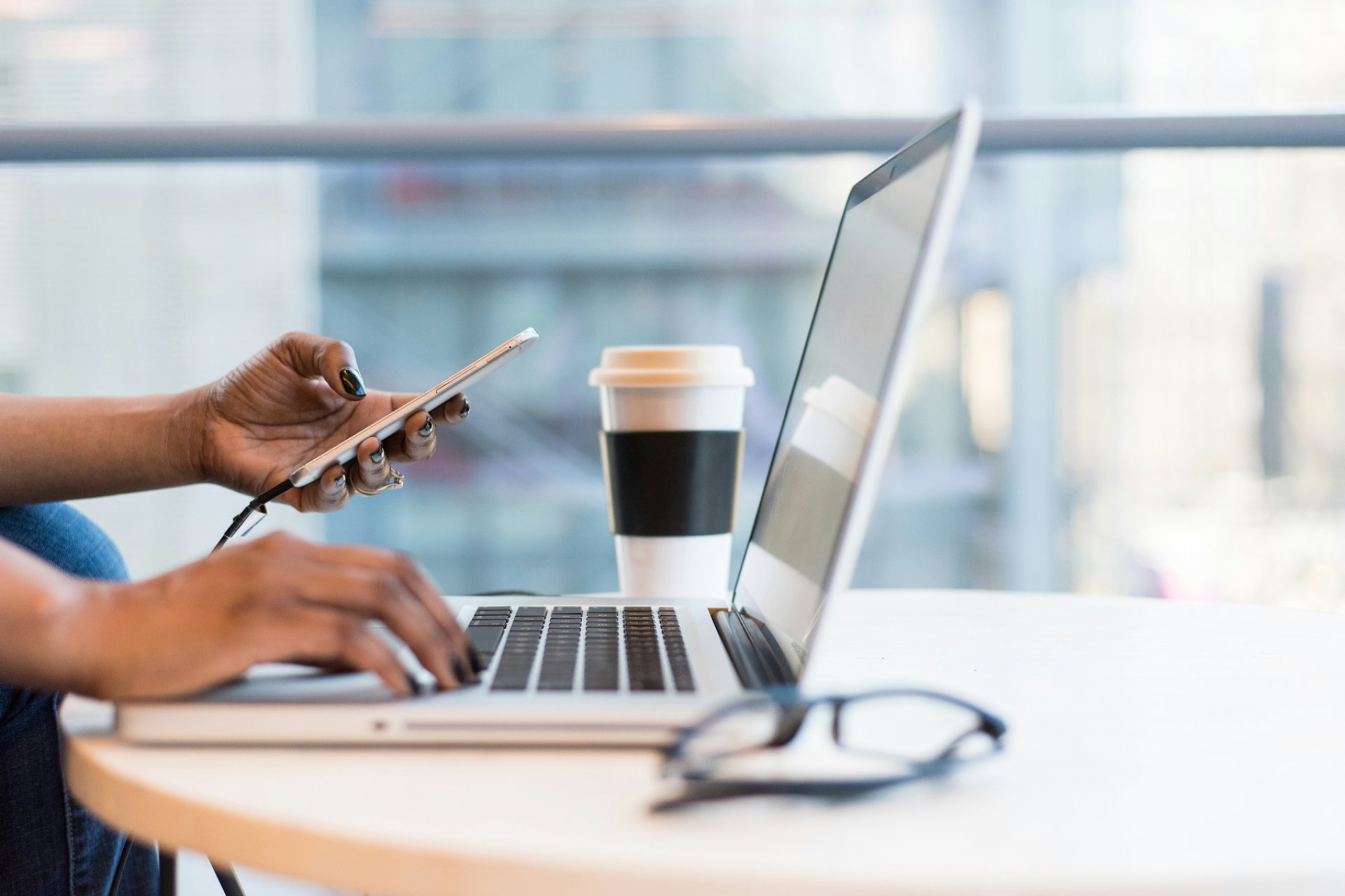 Photo of person using laptop and phone